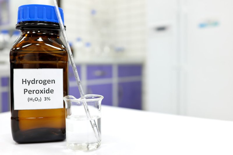 Close-up of hydrogen peroxide solution in a small glass container