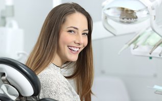 Dentist showing patient her smile after professional teeth whitening in North York