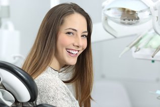 Dentist showing patient her smile after professional teeth whitening in North York